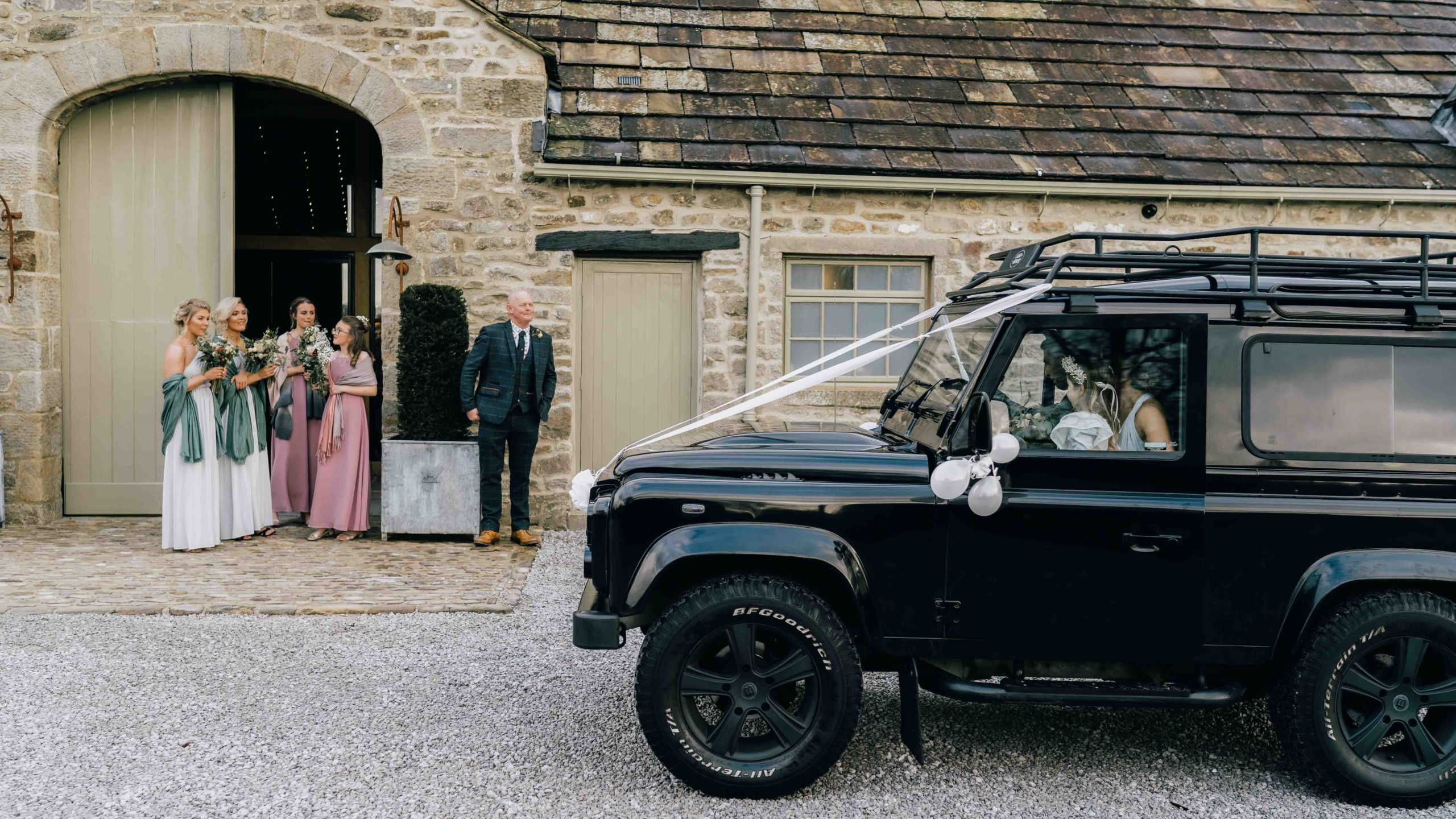 Bride arriving by landrover to her wedding at the Tithe Barn