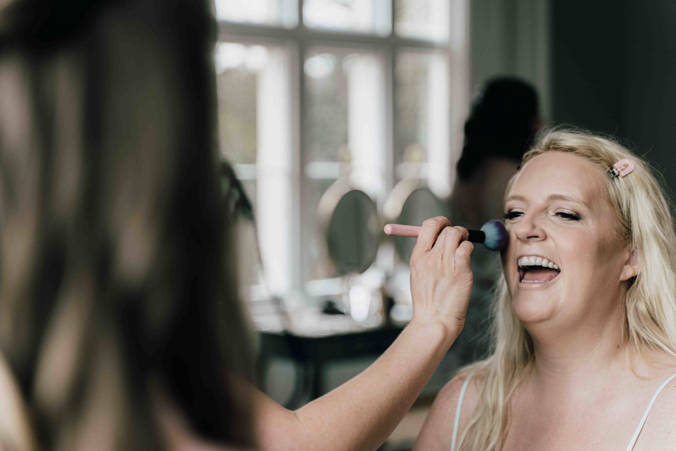 Charlotte getting her makeup done in the Thicket priory bridal suite